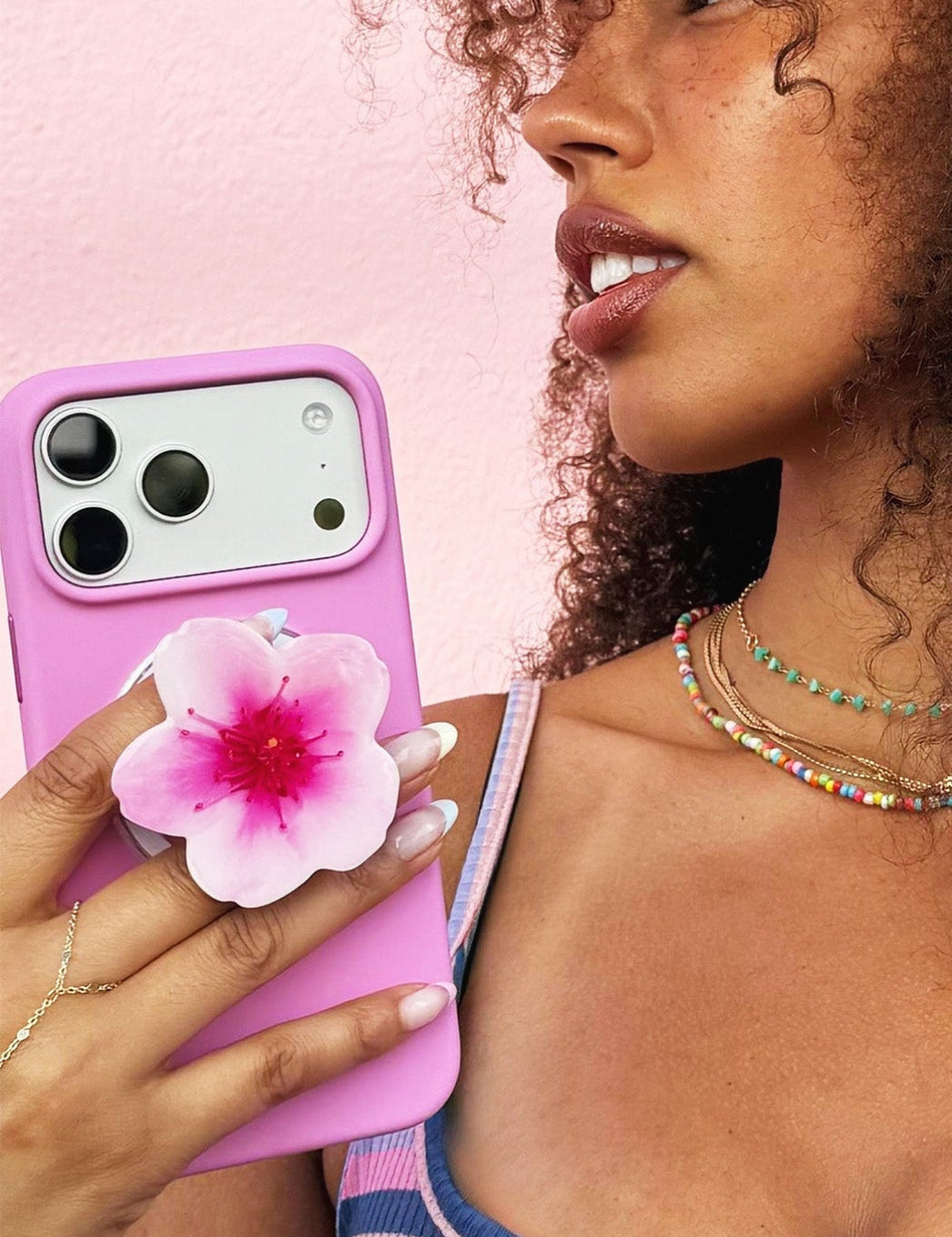 Woman holding Handcrafted pink cherry blossom phone grip with MagSafe compatibility on a pink case iPhone - Untouched Blooms Spring Collection